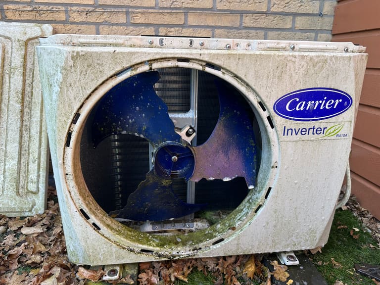 Carrier airco buitenunit met alg- en mosaanslag voor reiniging in Assen